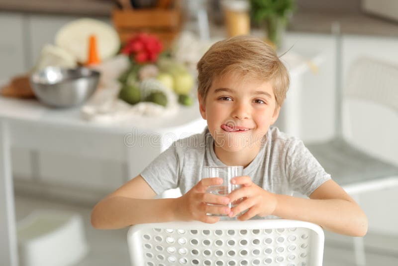 Underbart barn 8 år sitter på en stol och ser ut att vara med i kameran arkivfoton