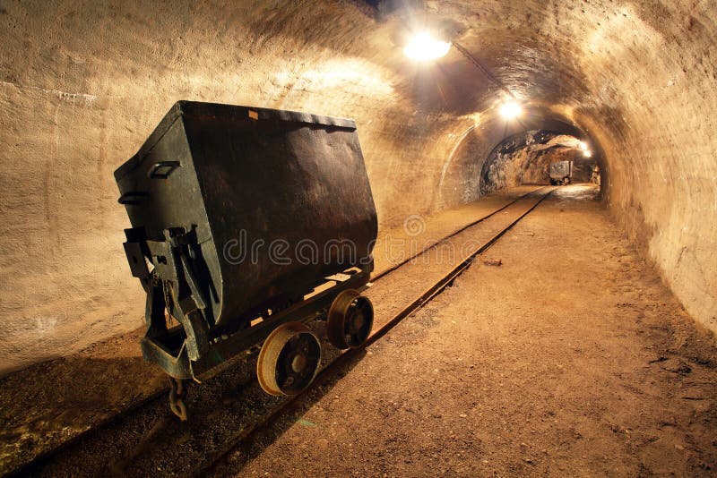 Underground train in mine, carts in gold, silver