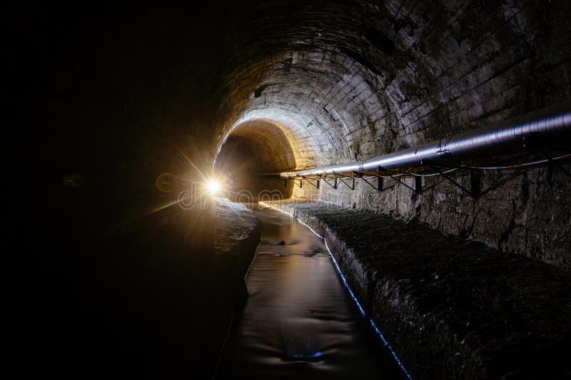 Underground Vaulted Urban Sewer Tunnel with Dirty Sewage Stock Photo