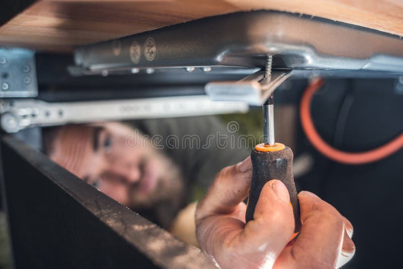 Man using a small screwdriver in a confined space