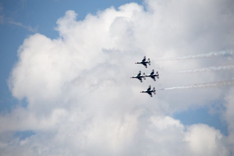 The underside of four USAF Thunderbirds against a cloudy sky, trailing smoke. The underside of four USAF Thunderbirds against a cloudy sky, trailing smoke.