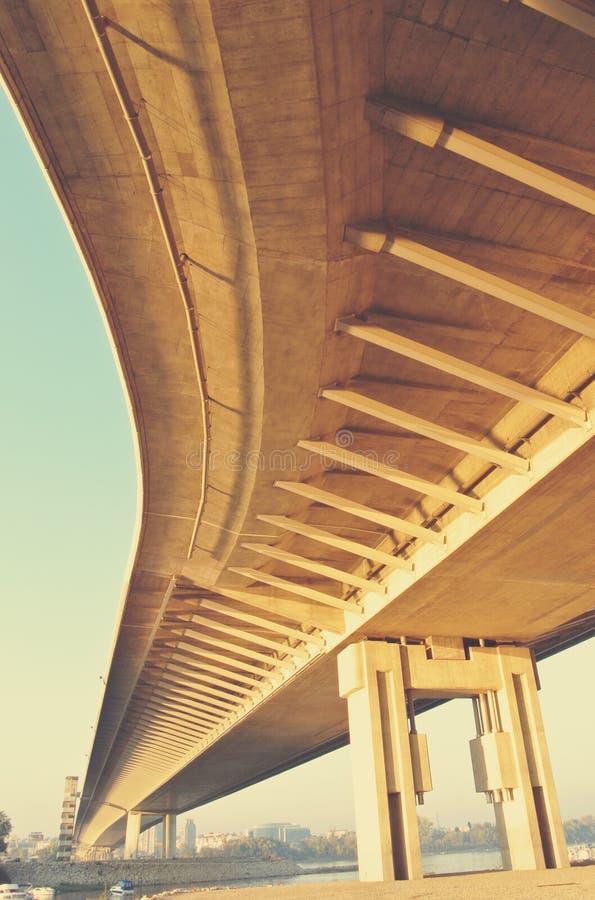 Inferiore di una lunga, giallo, avvolgimento ponte in un pomeriggio di sole.