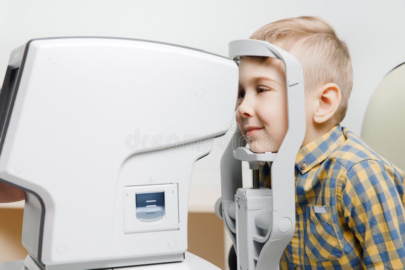 Undersökande vision för ögonläkarekvinnadoktor av det lilla barnet i klinik royaltyfri bild Undersökande vision för ögonläkarekvinnadoktor av det lilla barnet i klinik royaltyfri bild