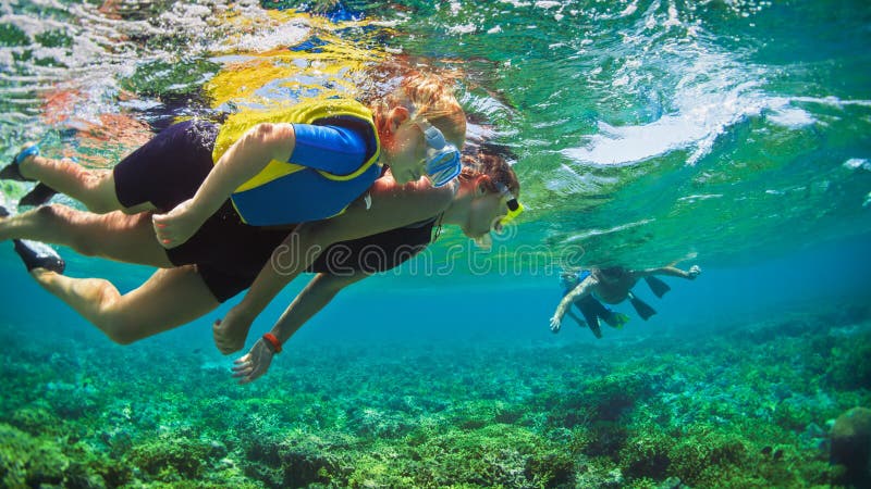 Underwater photo. Happy family snorkelling in tropical sea