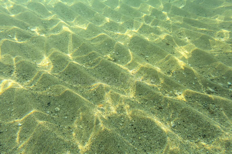 Underwater photo - seafloor, sun shines on sand stock photo Underwater photo - seafloor, sun shines on sand stock photo