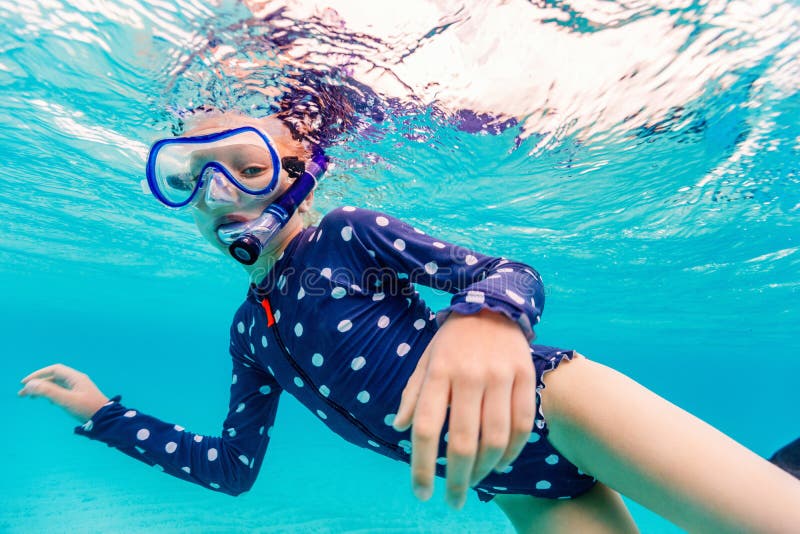 Underwater photo of young girl swimming and snorkeling in tropical ocean. Underwater photo of young girl swimming and snorkeling in tropical ocean