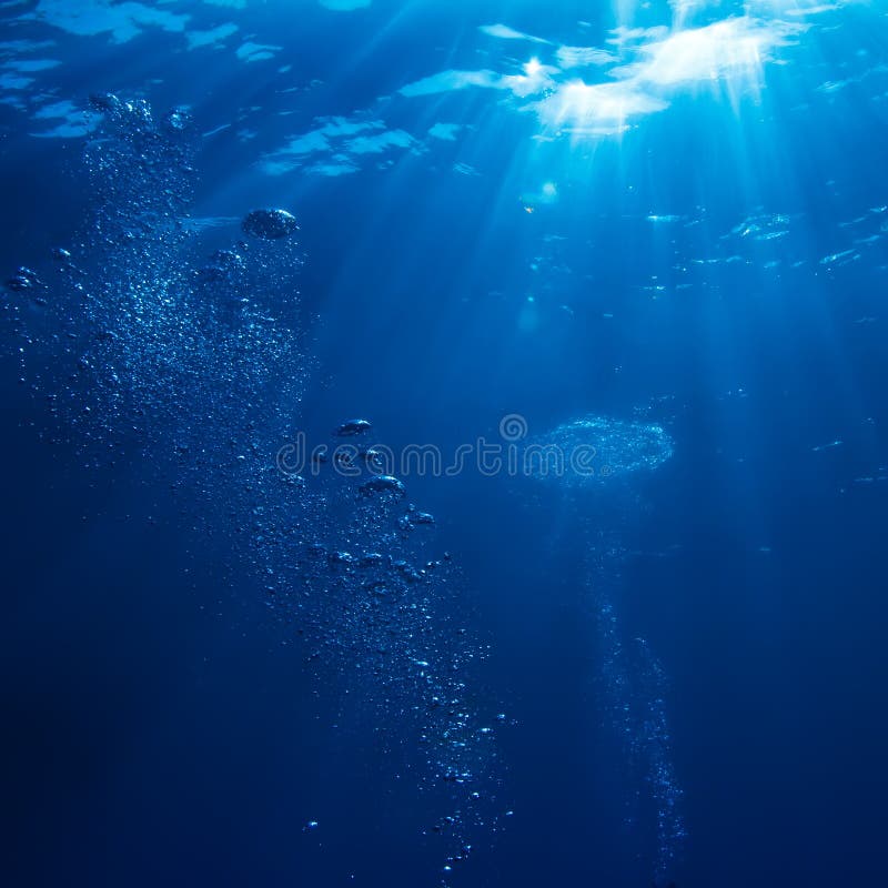 Abstracto escena rayos de sol a el aire burbujas en profundo azul el mar.