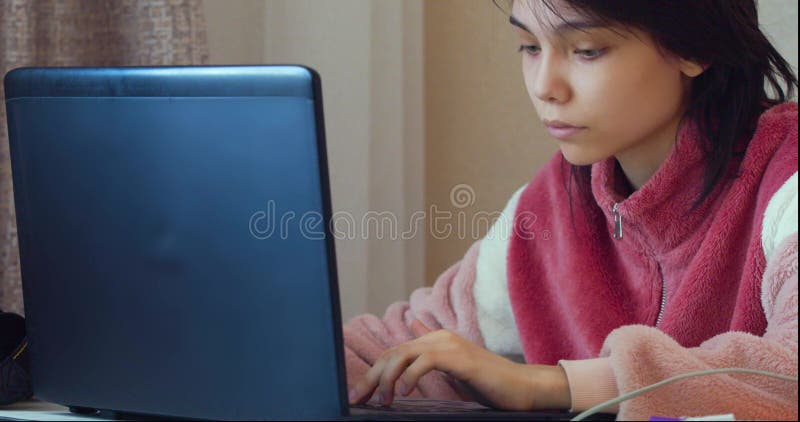 Une adolescente caucasienne devant un ordinateur portable à la maison. Éducation en ligne. clips vidéos