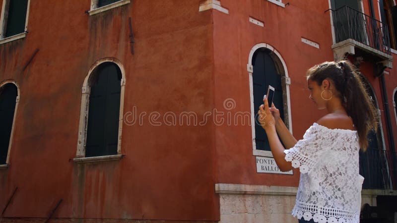 Une adolescente prend des photos contre la vieille maison vénitienne vue de près clips vidéos