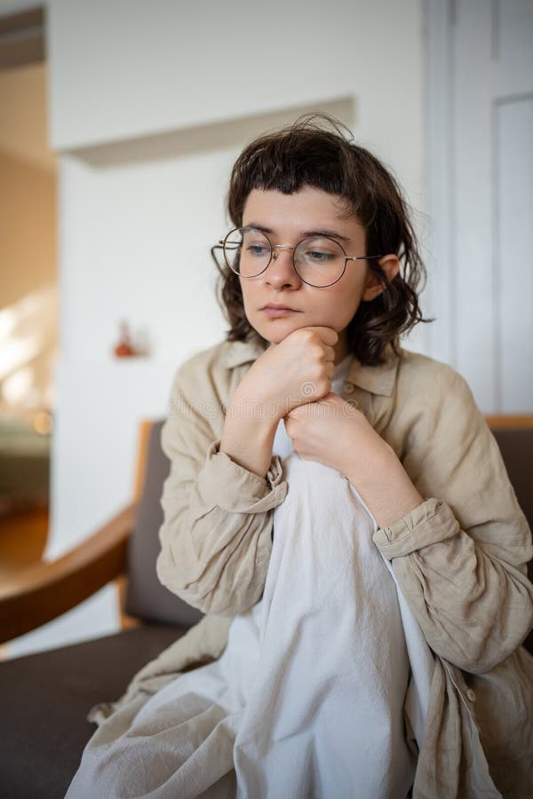 Une adolescente solitaire et attentionnée dans les lunettes, éprouver de l'apathie, malheureusement, à réfléchir assise sur un can photographie stock libre de droits