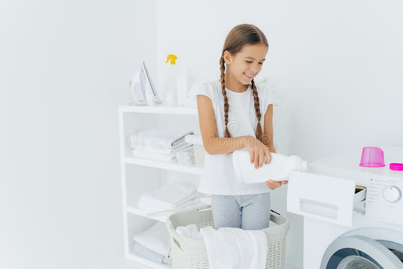 Une Fille Organisée Travailleuse Qui Nettoie Dans Un Appartement Une Femme  Se Tient Dans La Buanderie Près D'un Sèche-linge