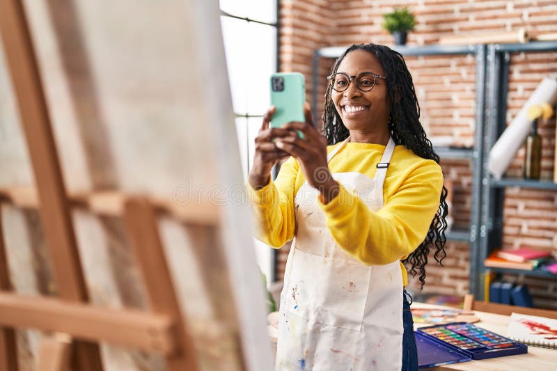 Une artiste afro-américaine se fait photographier par le smartphone pour dessiner au studio art