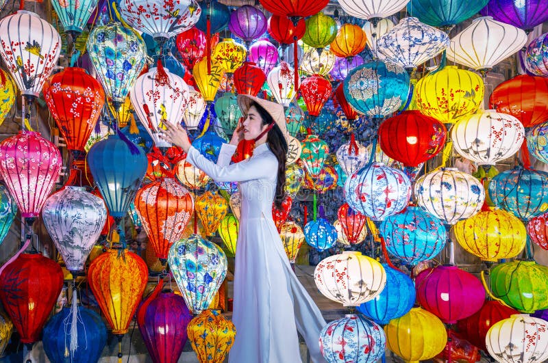 Une asiatique portant ao dai robe vietnamienne avec des lanternes colorées voyage à hoi une ville ancienne dans le centre du vietn photos libres de droits