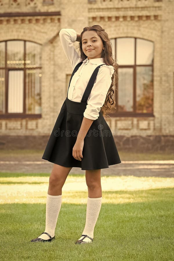 Une bonne tenue. écolière heureuse en uniforme élégant. bonheur d'enfance. mode enfant vintage. petite fille étudiante détente images libres de droits