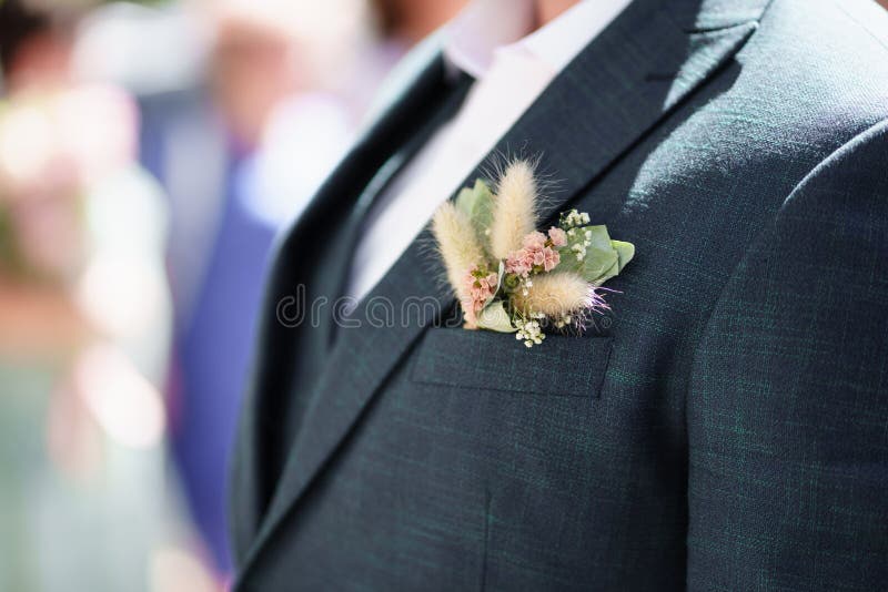 a dried flower boutonniere in the pocket of a man& x27;s jacket. a traditional decoration of the groom& x27;s wedding costume. a dried flower boutonniere in the pocket of a man& x27;s jacket. a traditional decoration of the groom& x27;s wedding costume.