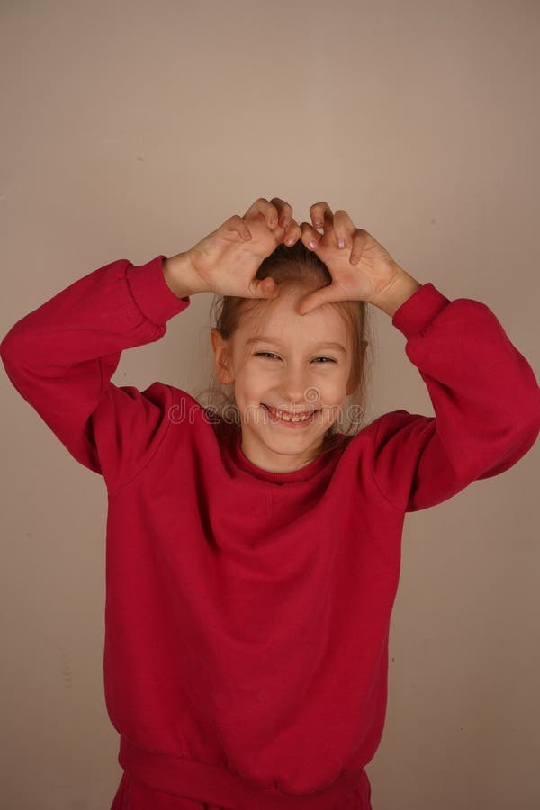 Une charmante représentation de la créativité et de l'humour de la jeunesse. Une jeune fille joyeuse sourit avec joie en faisant p photographie stock libre de droits