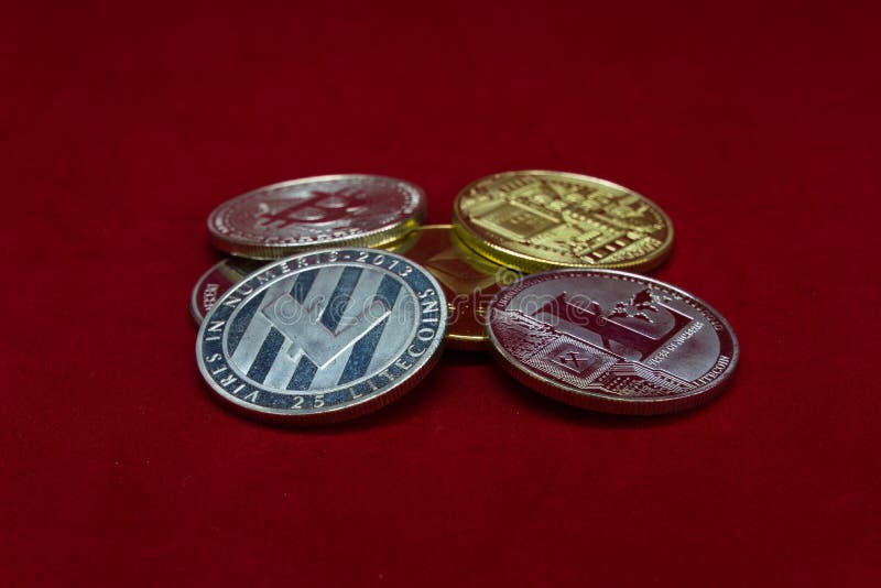 Une collection de pièces de monnaie de cryptocurrency d'argent et d'or sur un fond rouge de velours images stock Une collection de pièces de monnaie de cryptocurrency d'argent et d'or sur un fond rouge de velours images stock