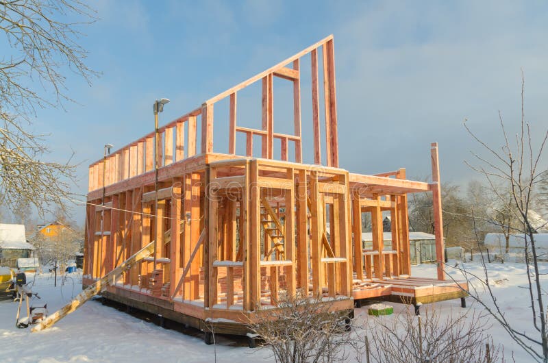 Une construction de maison en bois de cadre sur la base de pile dans le winte image libre de droits Une construction de maison en bois de cadre sur la base de pile dans le winte image libre de droits