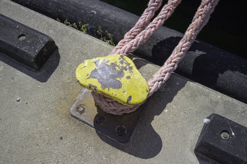 Une corde jaune et rose est attachée à un objet métallique image stock
