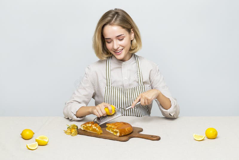 Une cuisine délicieuse substance fille assise à la table et de préparer un gâteau de citron images libres de droits