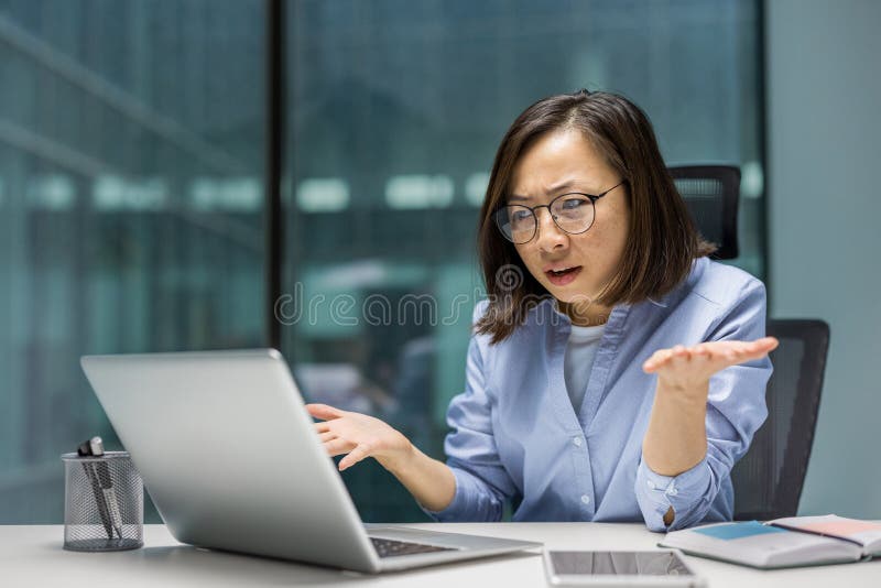 Une femme asiatique anxieuse et désespérée qui travaille avec un ordinateur portable à l'intérieur du bureau. Femme d'affaires sou photos libres de droits