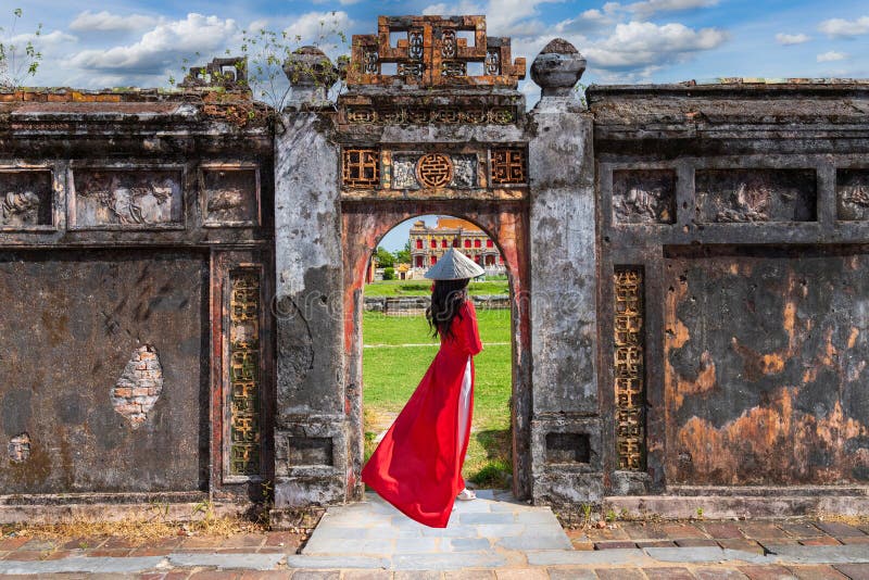 Une femme asiatique en robe ao dai visite le palais royal de la dynastie nguyen à hue vietnam images stock
