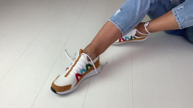Une femme branle des lacets sur des baskets banque de vidéos