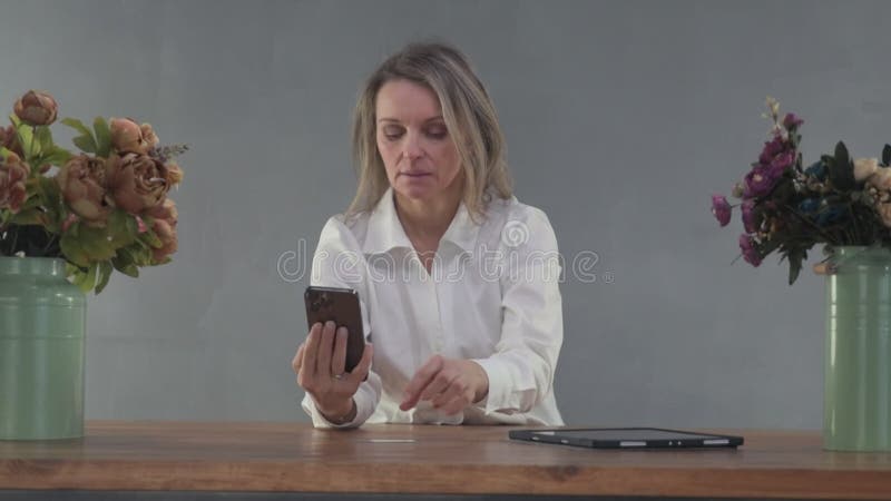 Une femme commande en ligne par téléphone à une table banque de vidéos