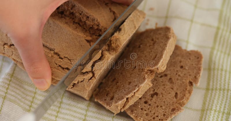 Une femme coupant du pain sans gluten brun