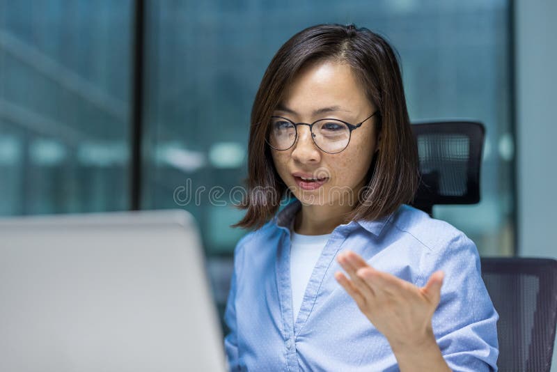 Une femme d'affaires sérieuse et ciblée discutant avec des collègues et des partenaires à l'aide d'un téléphone portable et vidéo. photographie stock libre de droits