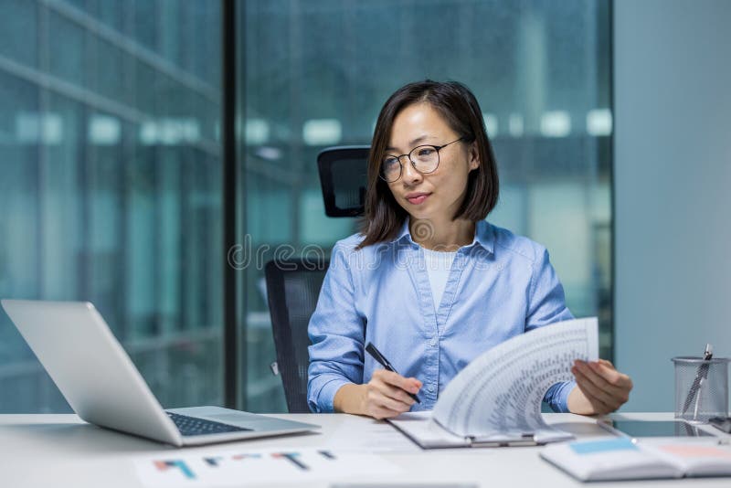 Une femme d'affaires sérieuse faisant de la paperasse financier efficace concentré préparation du rapport financier. comptable asi image stock