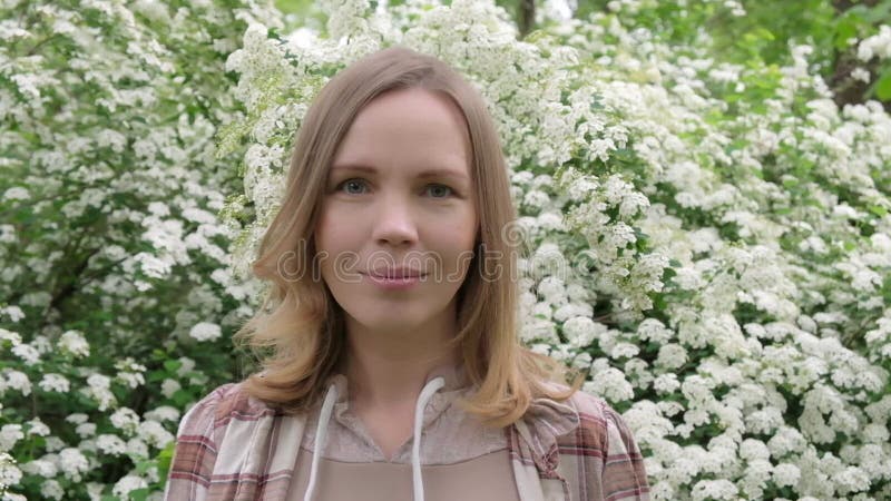 Une femme d'âge moyen regarde la caméra dans la nature banque de vidéos