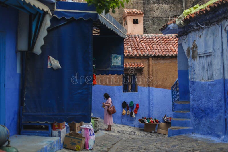 Une femme dans les rues bleues de Chefchaouens. photo stock