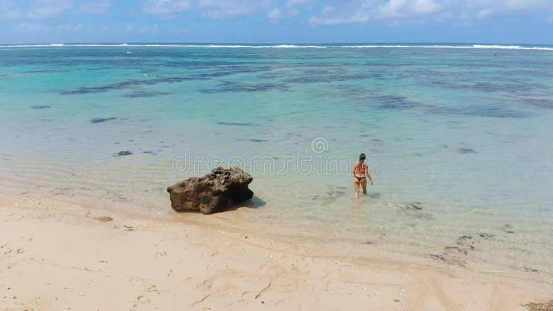 Une femme en bikini va nager dans l'océan calme clips vidéos