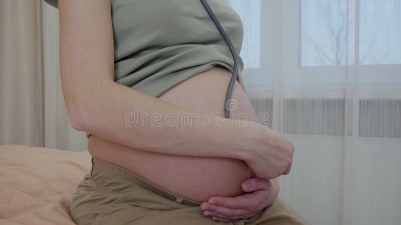 la femme enceinte utilise un stéthoscope pour écouter le cœur du bébé.  écouter les voix de