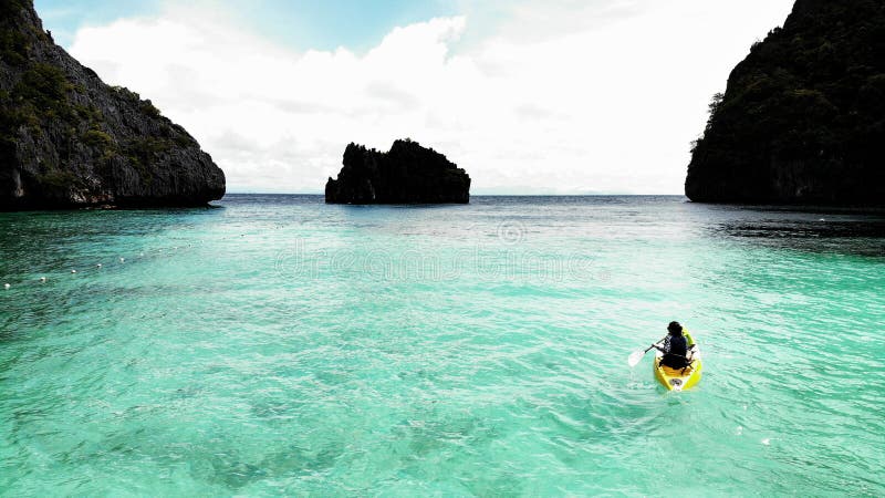 Une femme faisant du kayak dans les eaux cristallines de l'île aux chaussures de cheval dans la mer d'Andaman, la nature du Myanm photographie stock libre de droits Une femme faisant du kayak dans les eaux cristallines de l'île aux chaussures de cheval dans la mer d'Andaman, la nature du Myanm photographie stock libre de droits