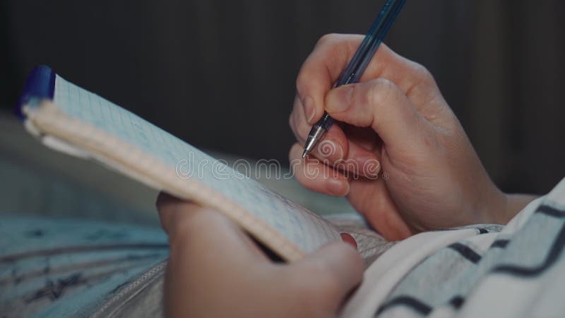 Une femme fait des notes dans un carnet de papier avec un stylo à bille. Gros plan. clips vidéos