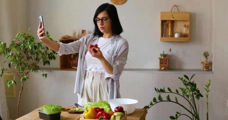 Une femme fait une leçon vidéo sur la cuisine sur téléphone portable smartphone banque de vidéos