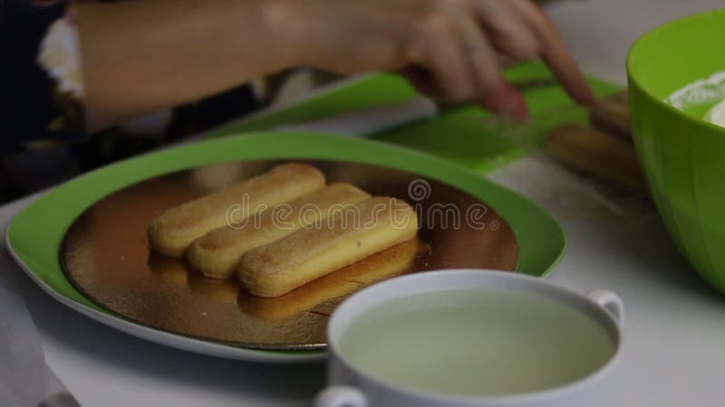 Une femme fait un gâteau à partir des biscuits Savoiardi Cookies d'immersion en sirop et configuration sur un substrat clips vidéos