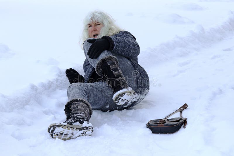 Une femme a glissé, est tombée et s'est blessée sur la route hivernale photo libre de droits Une femme a glissé, est tombée et s'est blessée sur la route hivernale photo libre de droits