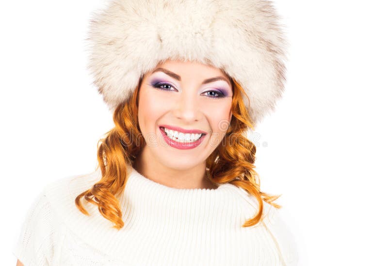 Une femme heureuse dans un chapeau d'hiver d'isolement sur le blanc photo stock