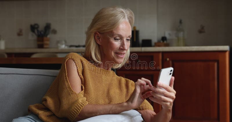 Une femme heureuse et moyenne utilise un smartphone taper un message banque de vidéos
