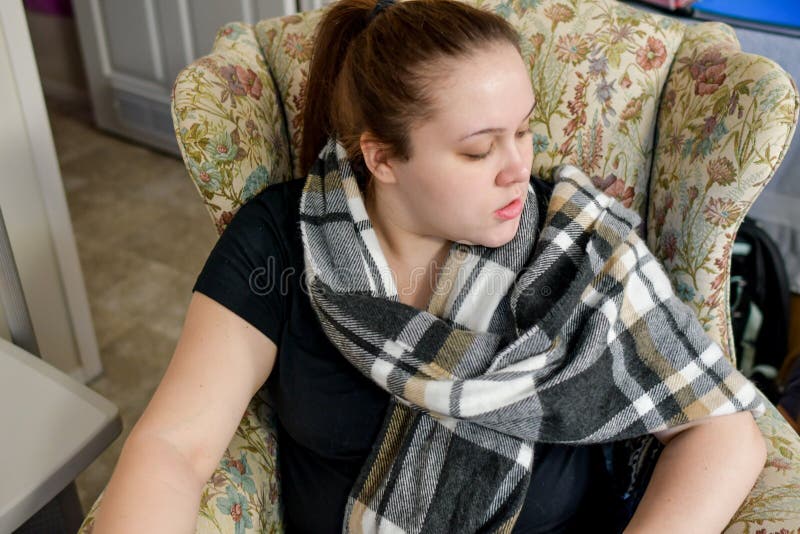 Une femme jette un coup d'oeil plus de dans un fauteuil jaune photographie stock libre de droits Une femme jette un coup d'oeil plus de dans un fauteuil jaune photographie stock libre de droits