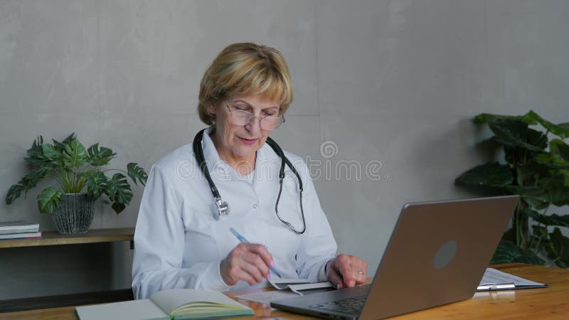 Une femme médecin communique avec un patient par vidéoconférence banque de vidéos