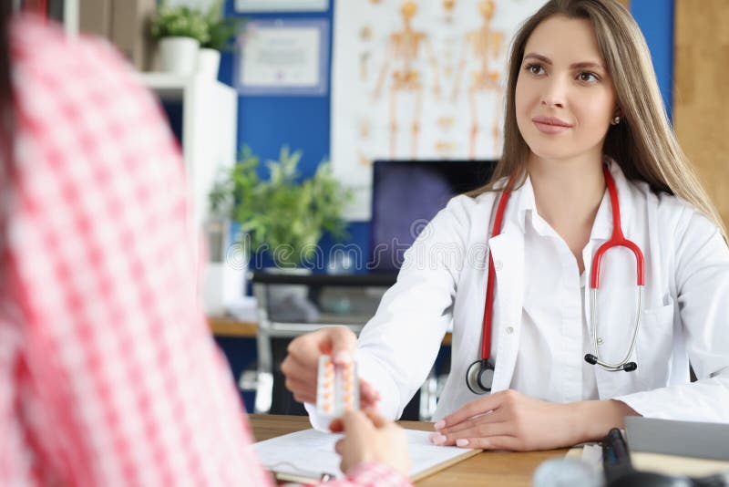 Portrait of qualified female doctor give tablets to patient for faster recovery. Woman on appointment get advice from professional. Medicine, help concept. Portrait of qualified female doctor give tablets to patient for faster recovery. Woman on appointment get advice from professional. Medicine, help concept