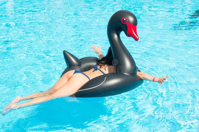 Une femme assise sur une bouée de sauvetage dans une piscine photo