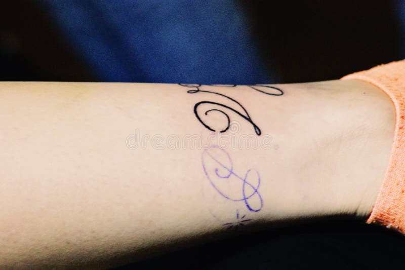 Une femme obtenant un tatouage de manuscrit photos stock Une femme obtenant un tatouage de manuscrit photos stock