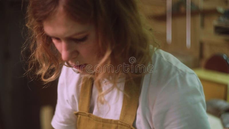 Une femme peint une partie en bois d'un produit en bois avec une brosse. idée d'entreprise pour un atelier à domicile