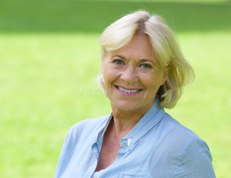Une femme plus âgée souriant dehors photo libre de droits