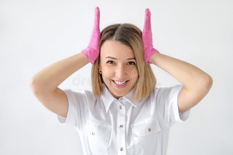 Une femme qui rit en uniforme médical et des gants roses tient la tête d'une attaque cérébrale et de l'excès d'information images libres de droits